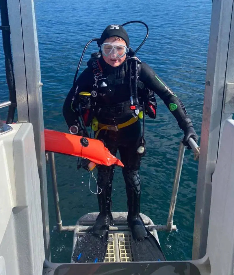 A young diver with equipment on a dive boat